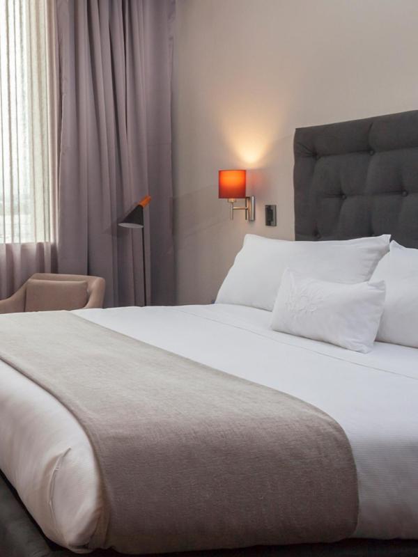 Mds Hotel Chillán Εξωτερικό φωτογραφία A bed with a throw